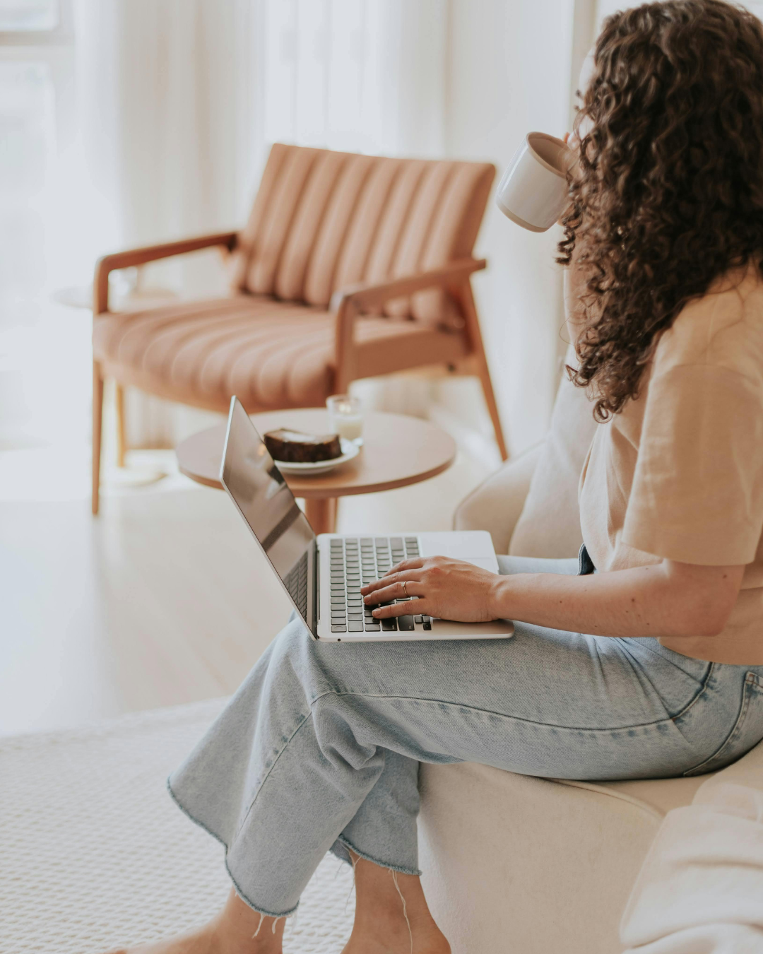 Woman with a coffee working on a laptop at home